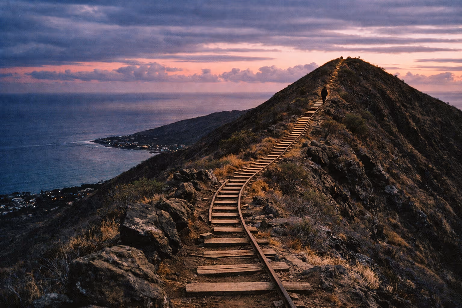 Old railway tracks ascend the ridge of Koko Crater with ocean and town views at sunset.