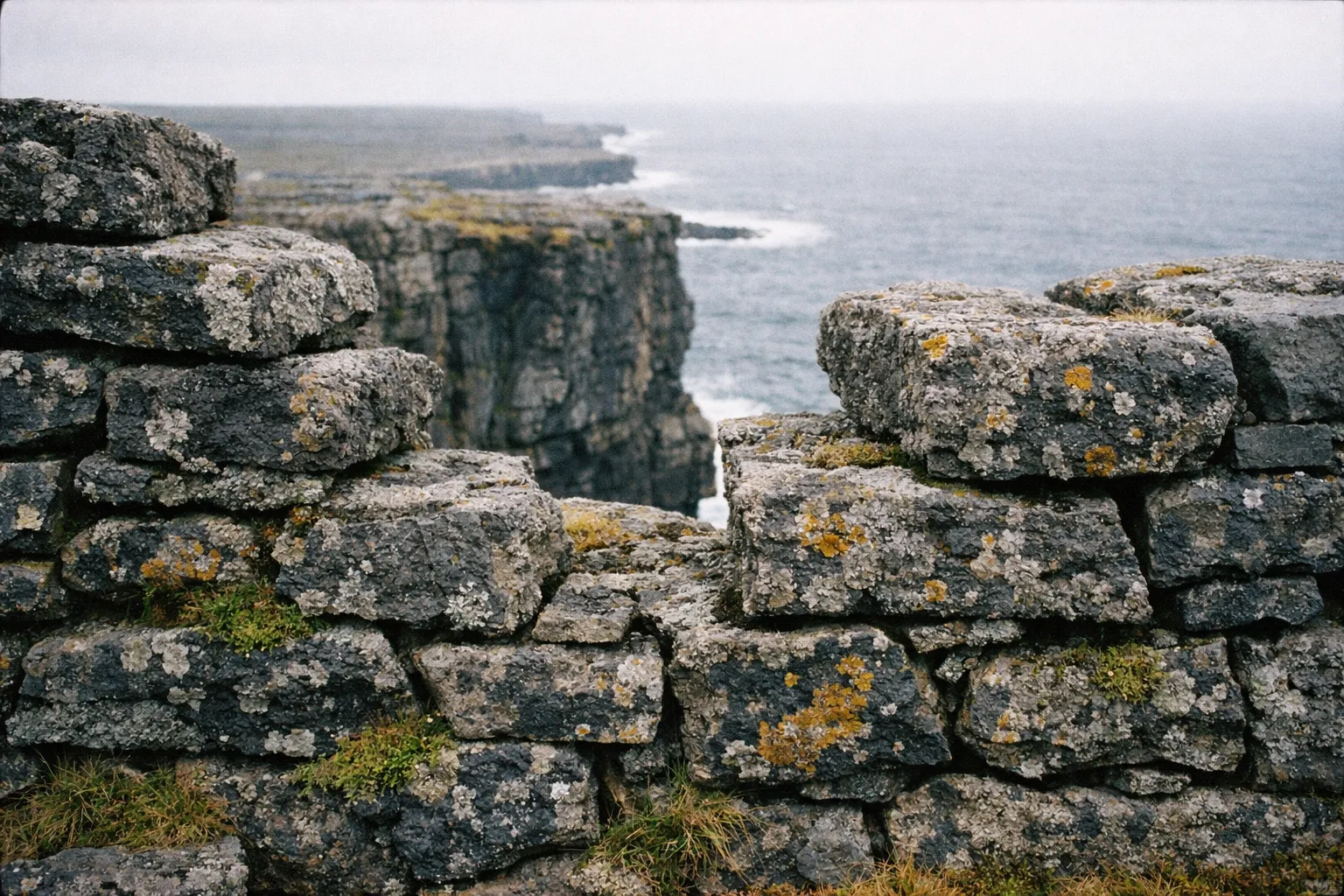 Ancient stone wall overlooking dramatic sea cliffs on Inishmore, Aran Islands, Ireland.