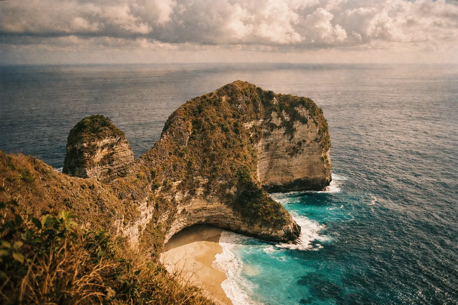 Kelingking Beach cliffs on Nusa Penida with turquoise water and dramatic sky