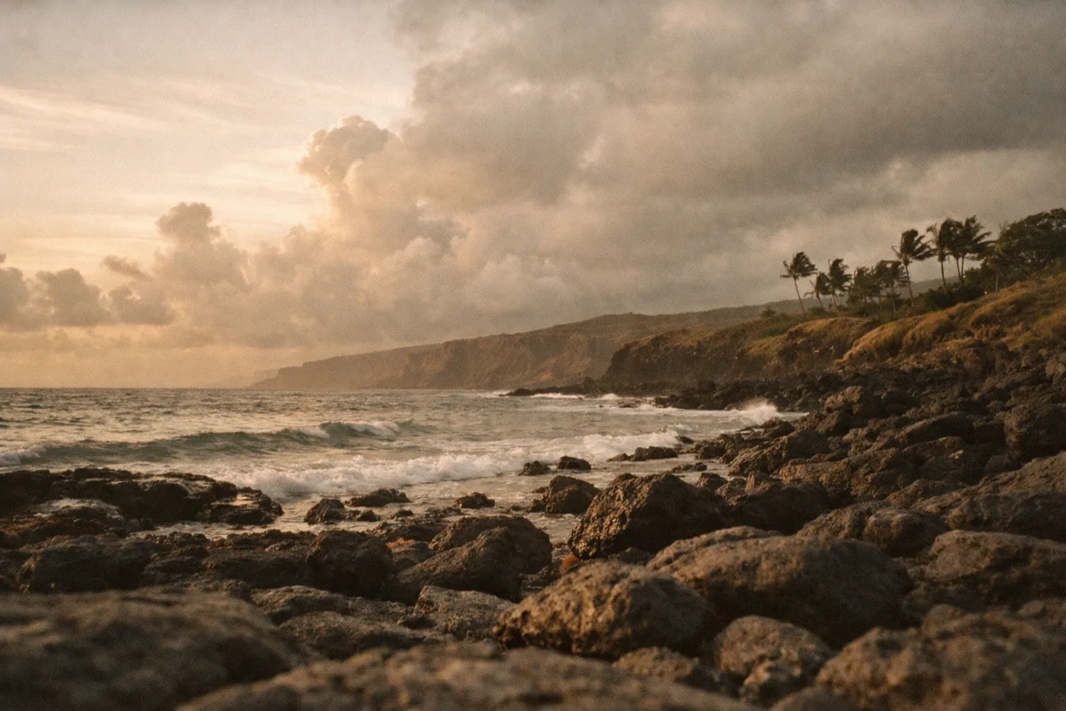 Coastal Hawaii at golden hour with lava rocks and calm waves, empty foreground