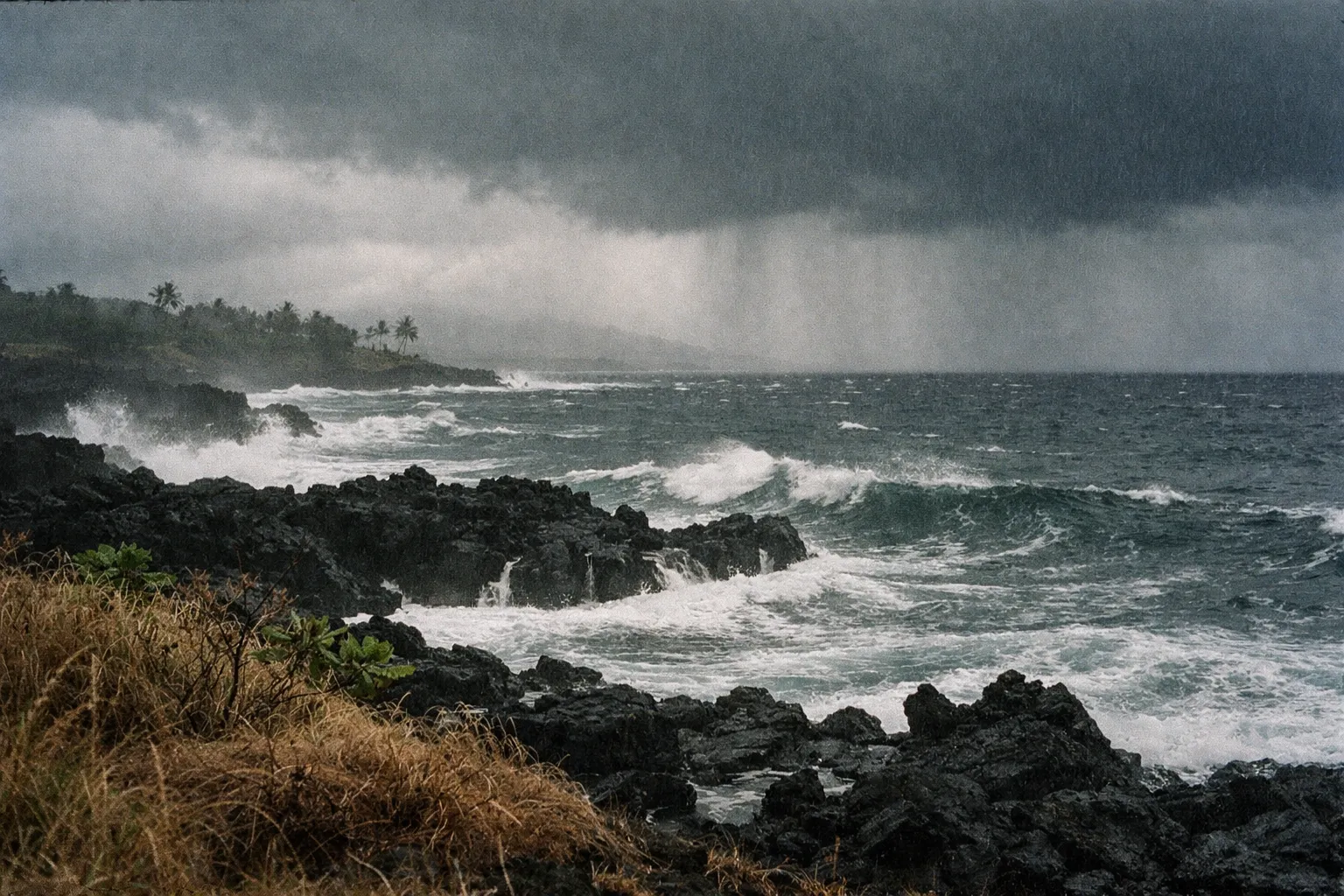 Stormy Hawaiian coast with dark clouds and rough seas over lava rocks