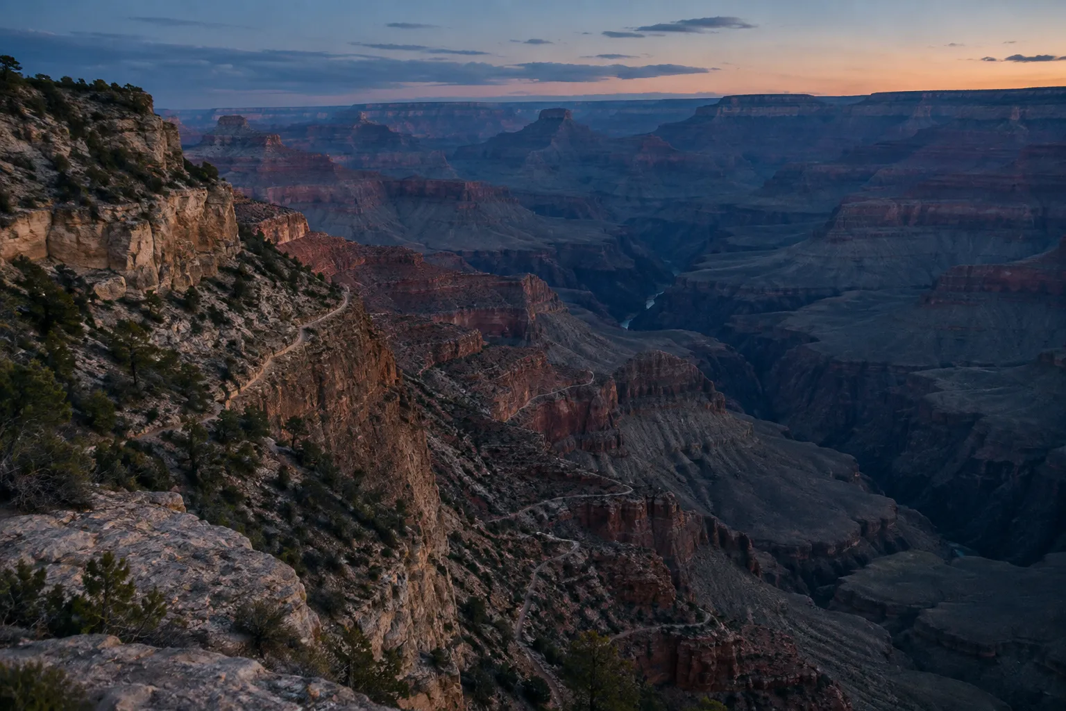 Bright Angel Trail switchbacks descend into the Grand Canyon at sunset.