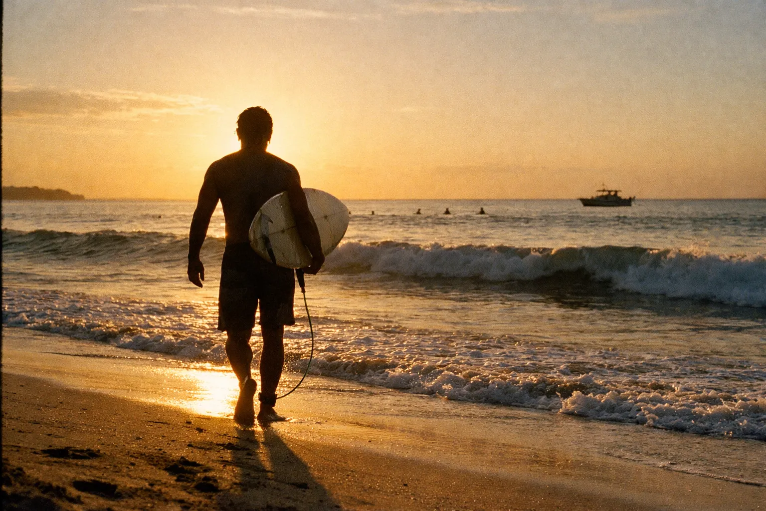 Surfer silhouette walking toward the water with a board at dawn on Tamarindo Beach