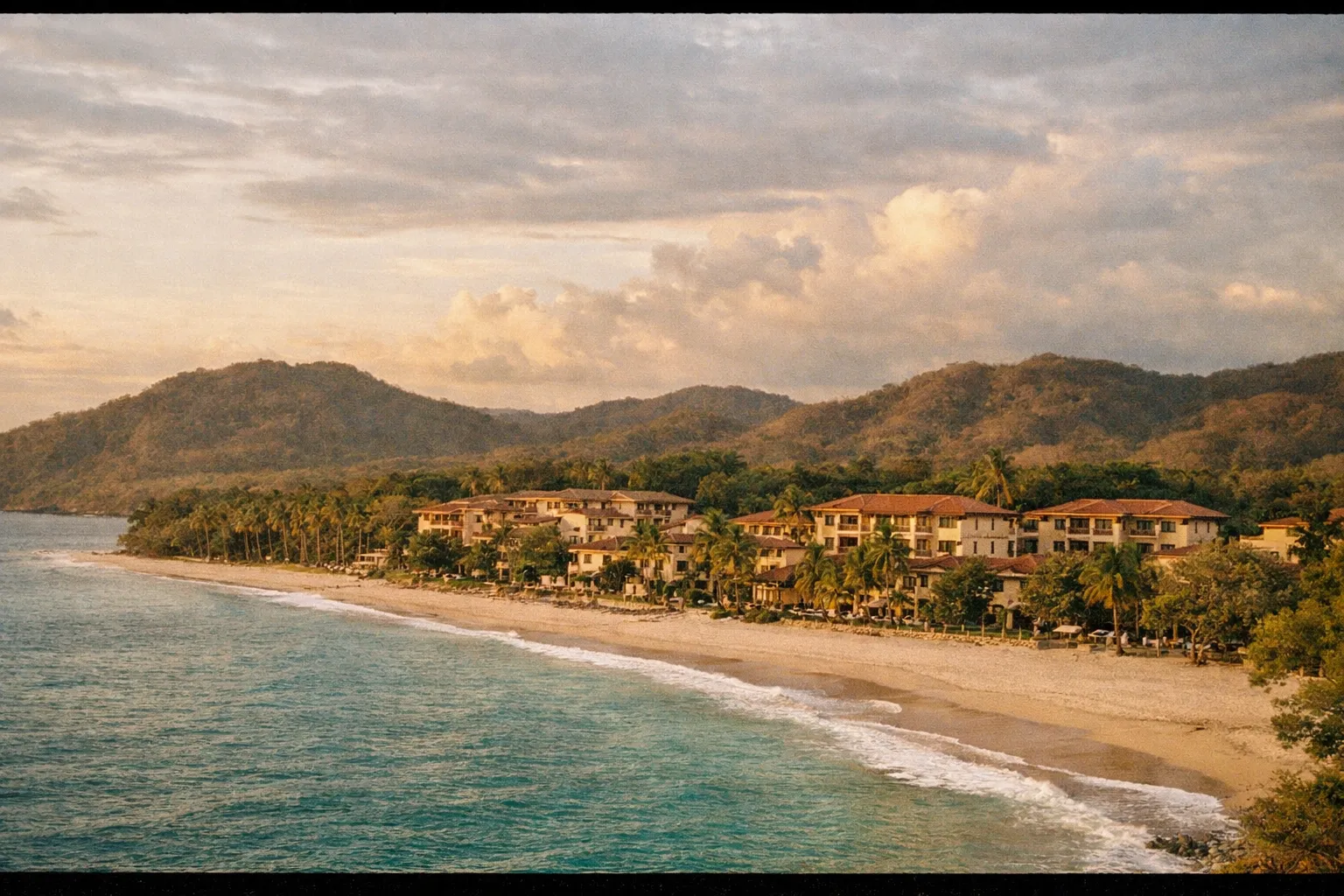 Coastal panorama of Guanacaste with cluster of low-rise resorts along a white-sand beach