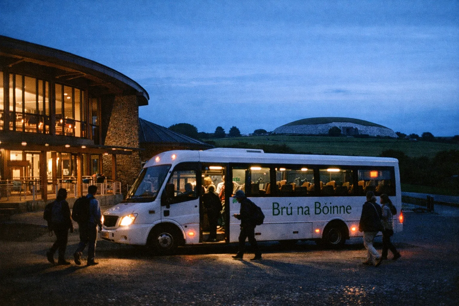 People boarding a tour bus labeled Brú na Bóinne outside a visitor center with Newgrange visible in the background.