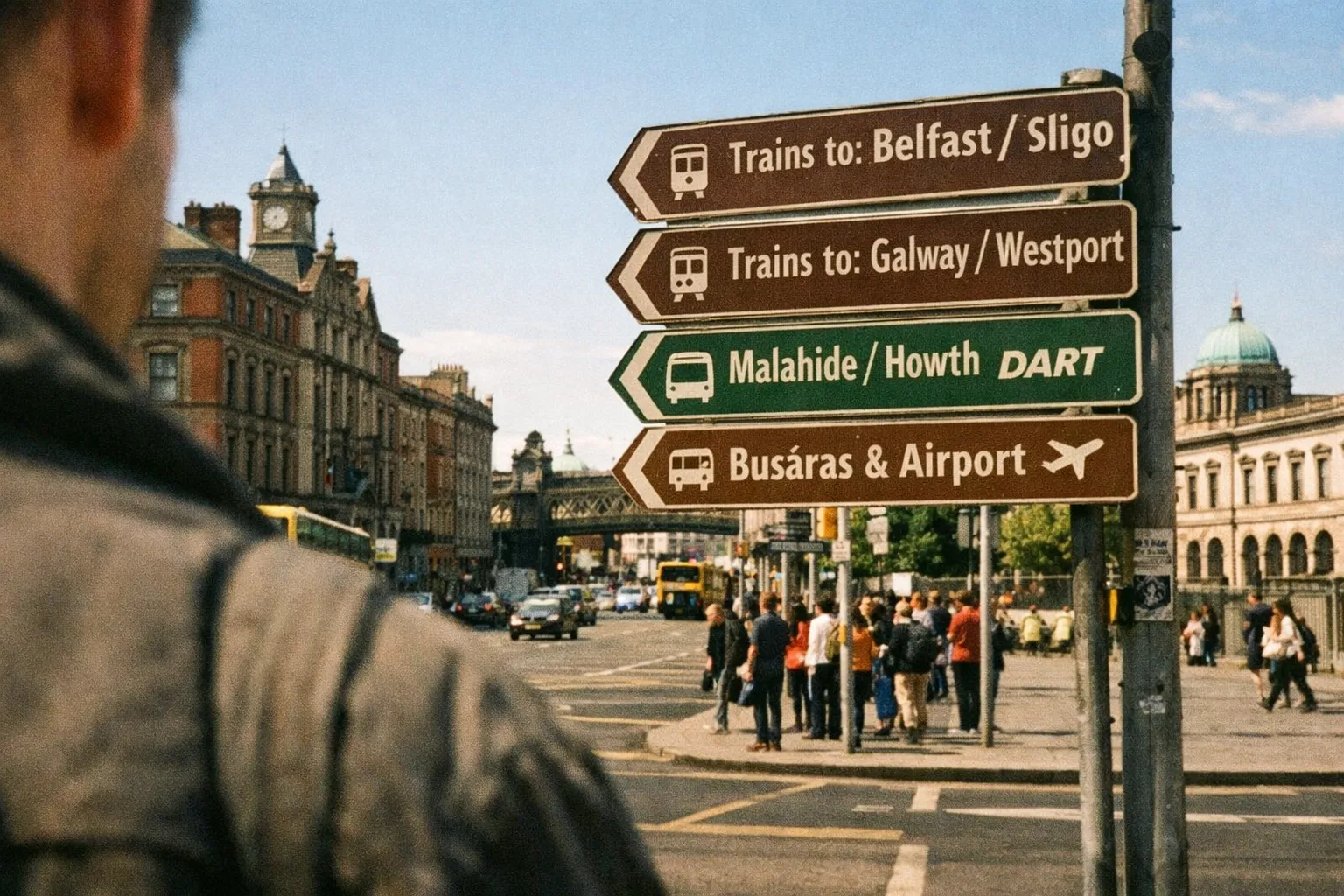 A man stands near street signs and historic buildings in central Dublin, Ireland.