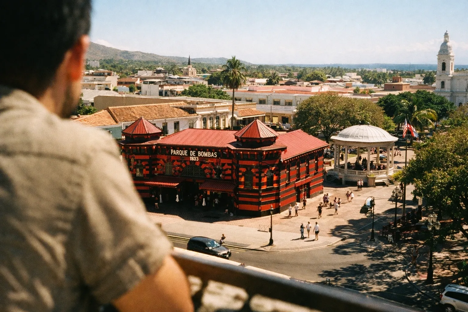 A person overlooks Parque de Bombas in Ponce, Puerto Rico, with a plaza and gazebo in view.