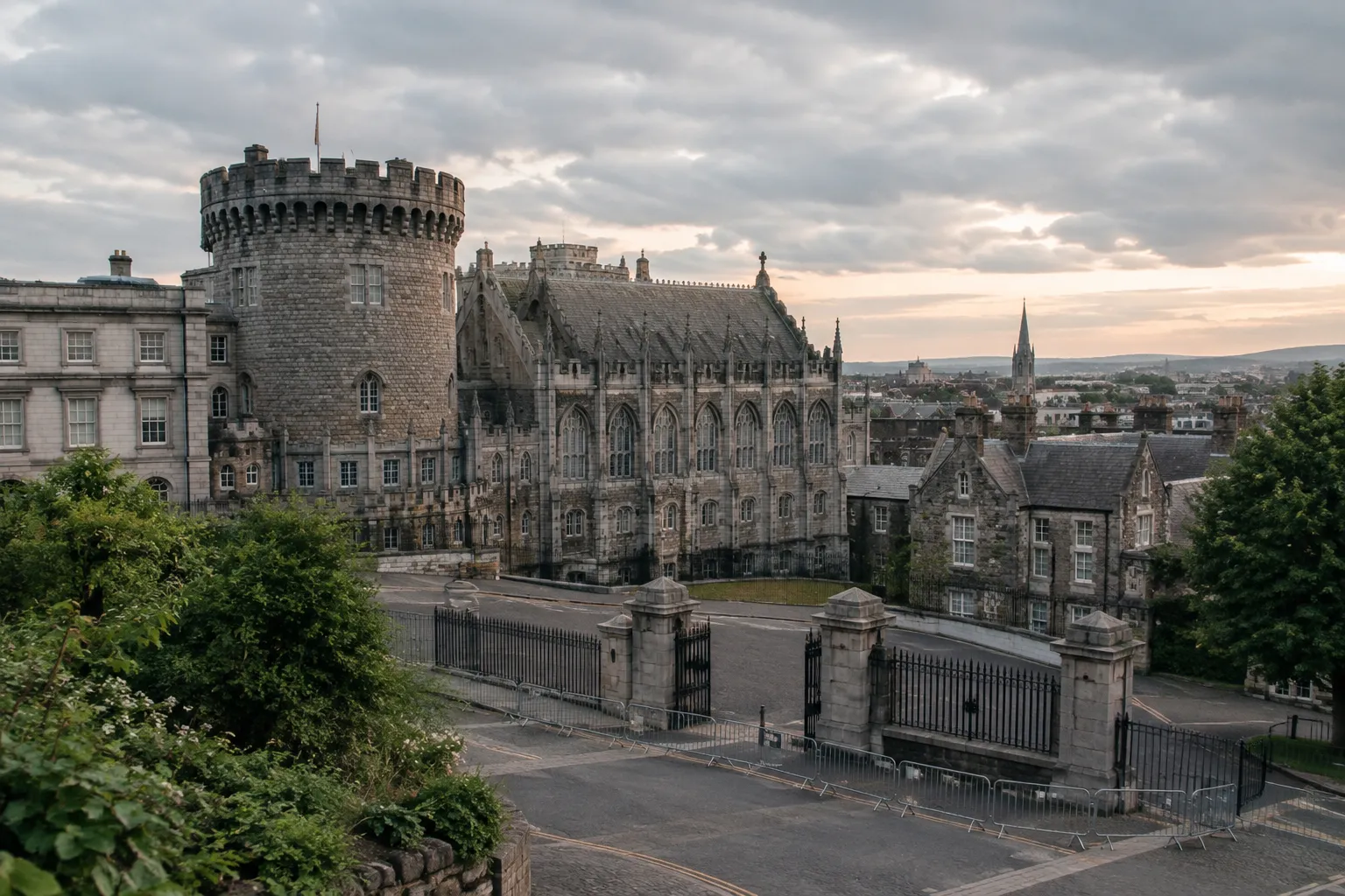 Dublin Castle's stone buildings and round tower rise above a gated courtyard in the city.