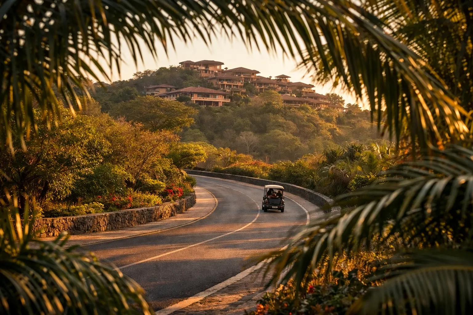 A golf cart drives along a winding road lined with tropical greenery toward hillside villas at Four Seasons Peninsula