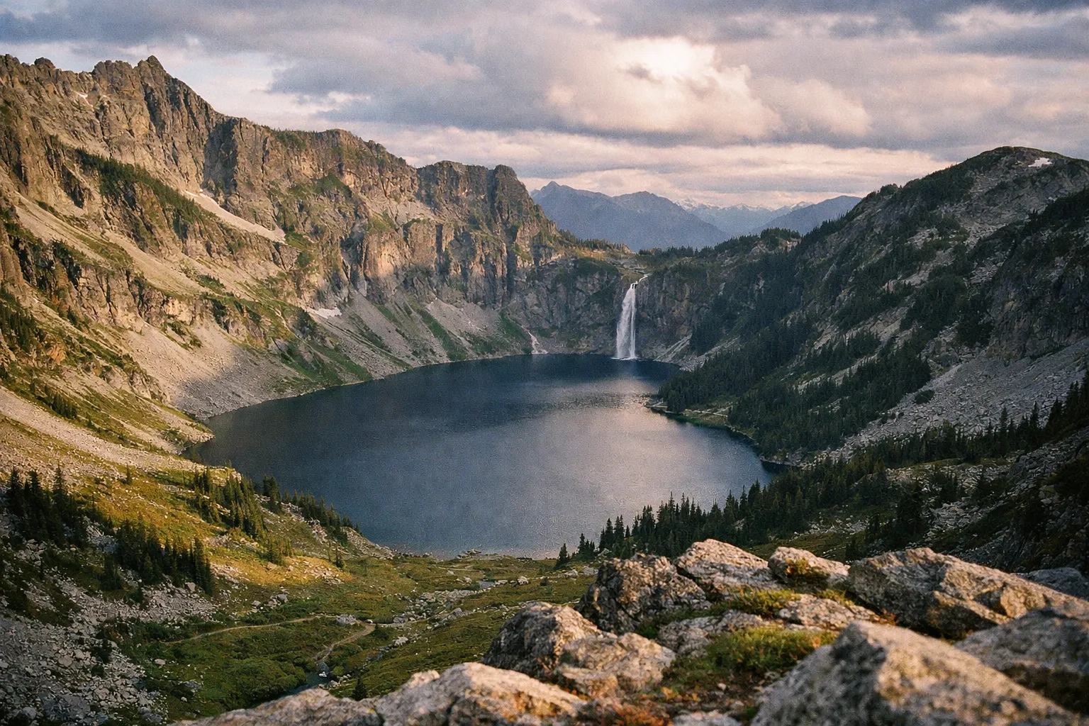 Doubtful Lake basin from an overlook with waterfall on the far side and cliff walls