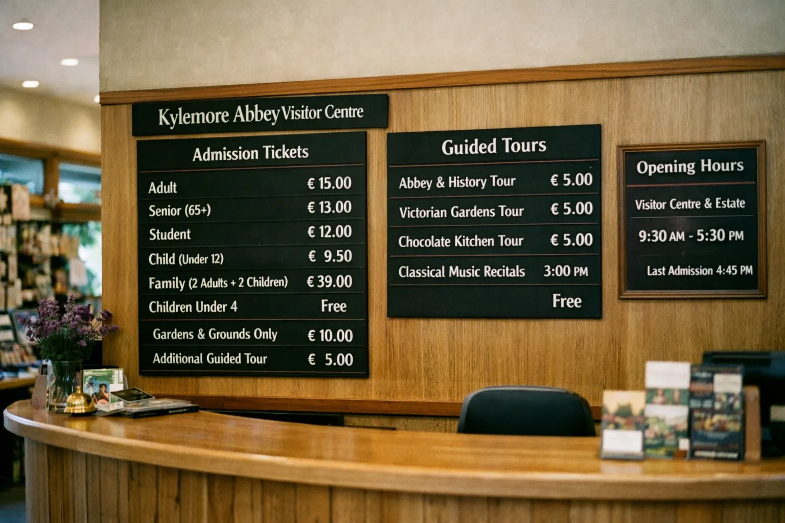 Reception desk at the Visitor Centre with ticket prices and tour information on wall signs.
