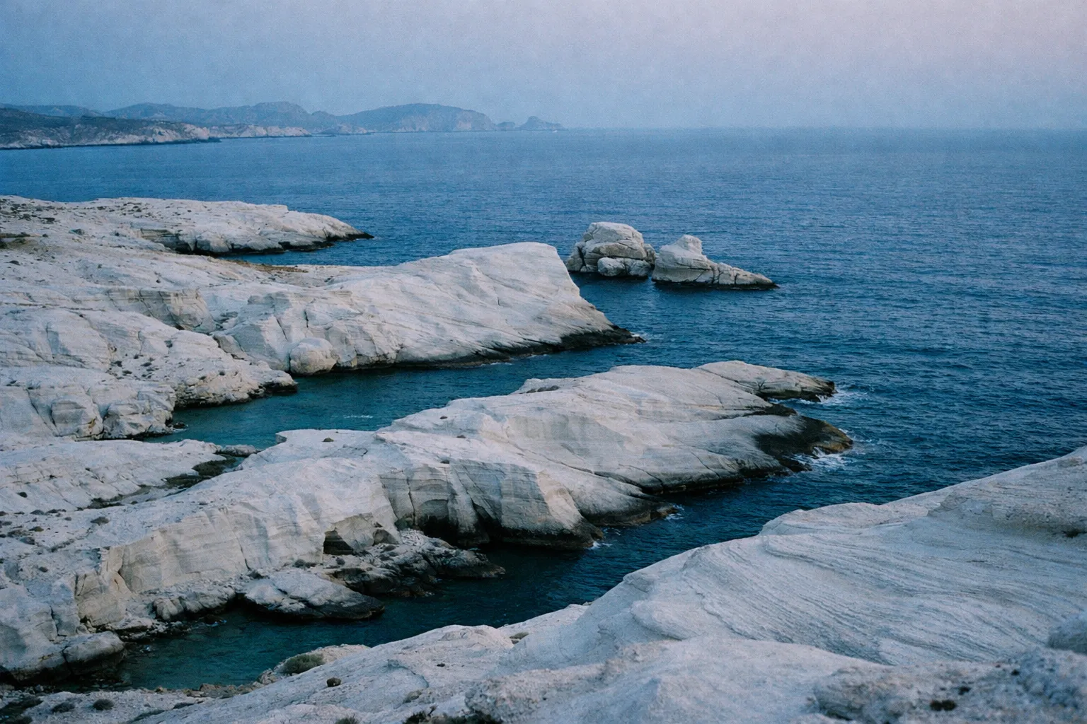 White rocky formations meet the blue sea at Sarakiniko Beach on Milos island, Greece.