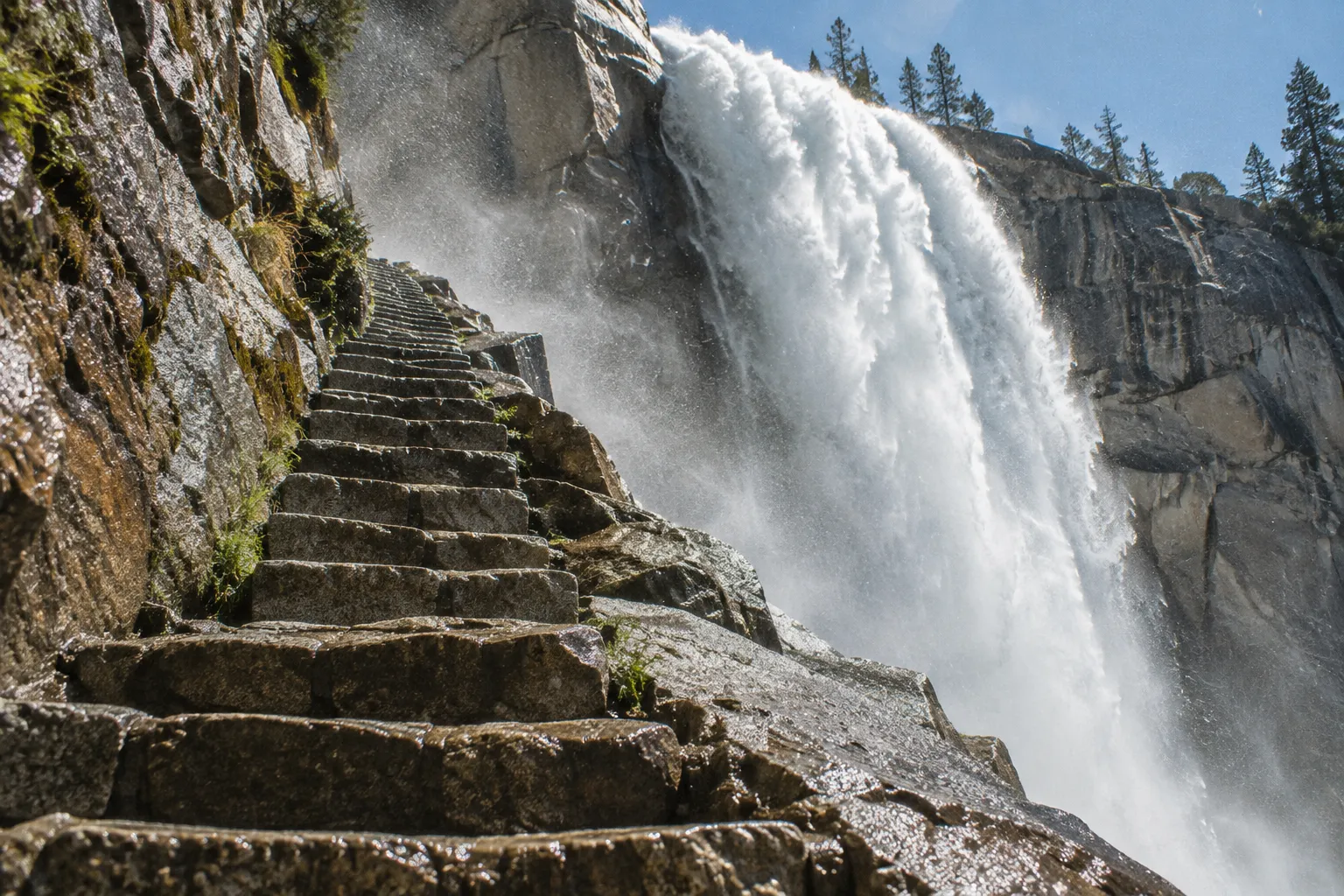 Stone steps climb beside a powerful waterfall on Yosemite's Mist Trail.