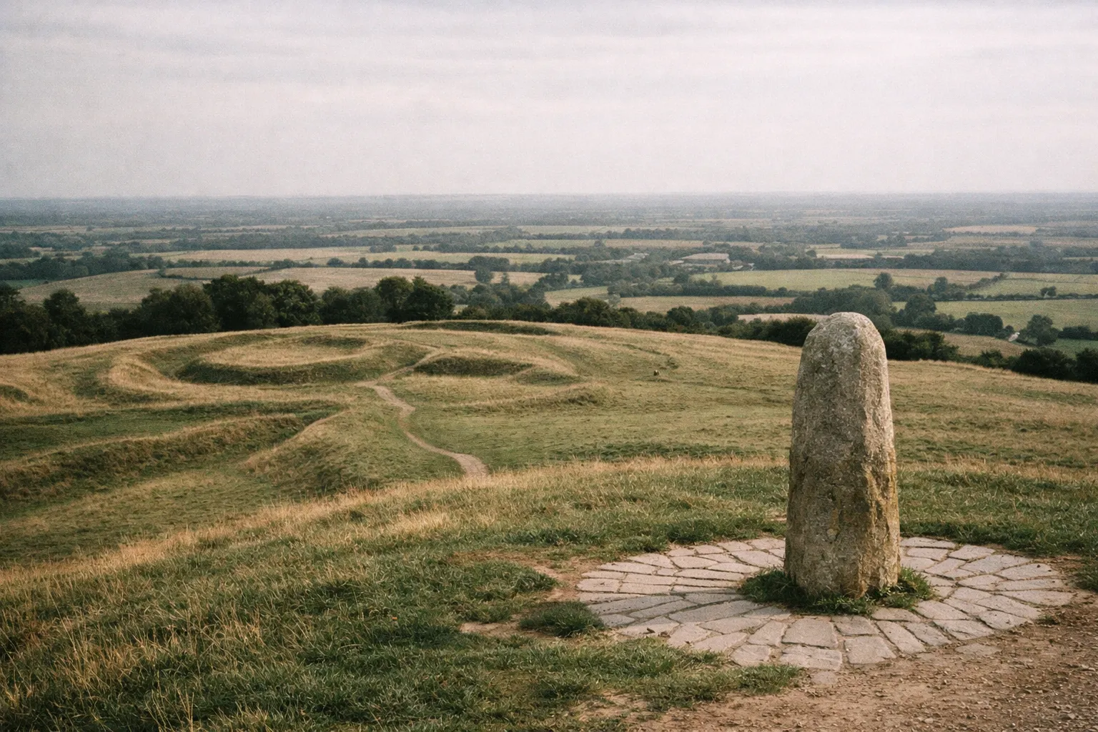 Standing stone on the Hill of Tara overlooking grassy earthworks and farmland in the Boyne Valley.