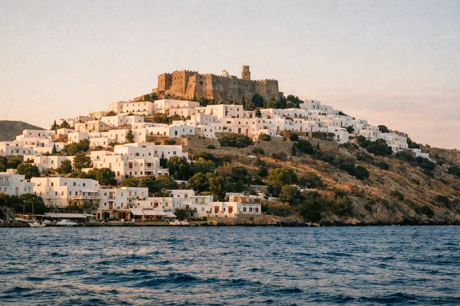 The Monastery of St. John dominates the hill above Chora with white houses clustered on Patmos island, Greece.