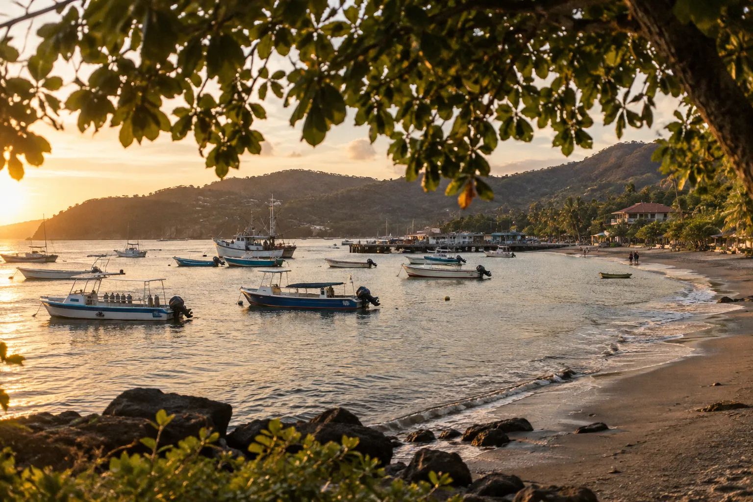 Boats anchor off a sandy beach at sunset in Playas del Coco, Costa Rica.