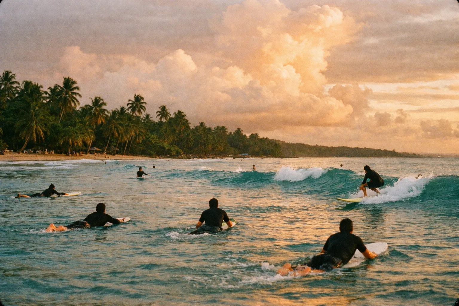 Surfers on the Caribbean coast of Puerto Viejo, seen from behind as they paddle out to the breaks at golden hour.
