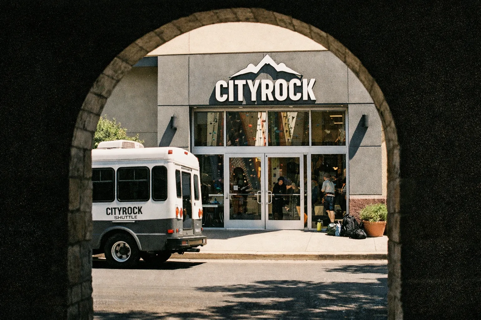 Entrance to CityROCK climbing gym in Colorado Springs with a shuttle bus parked outside.