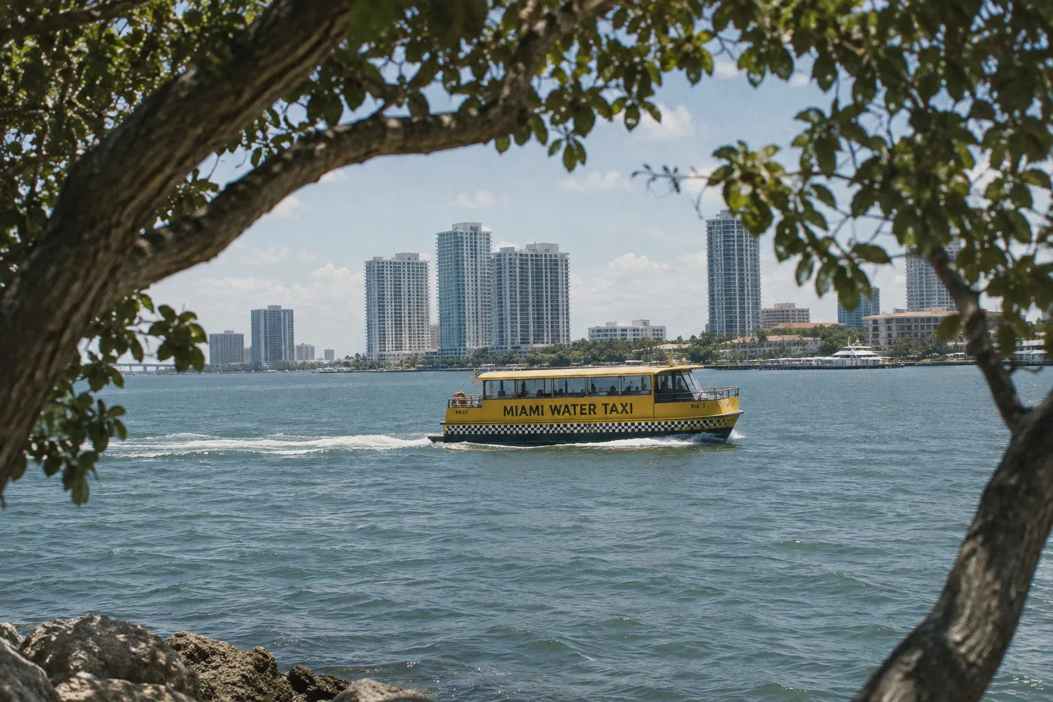 A Miami water taxi crosses the bay in front of the city's waterfront skyline.
