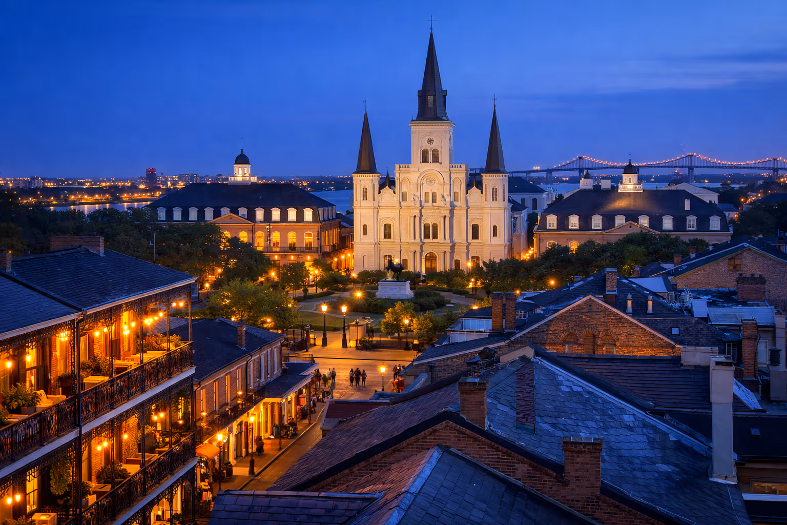 St. Louis Cathedral and Jackson Square lit up at dusk in the New Orleans French Quarter.