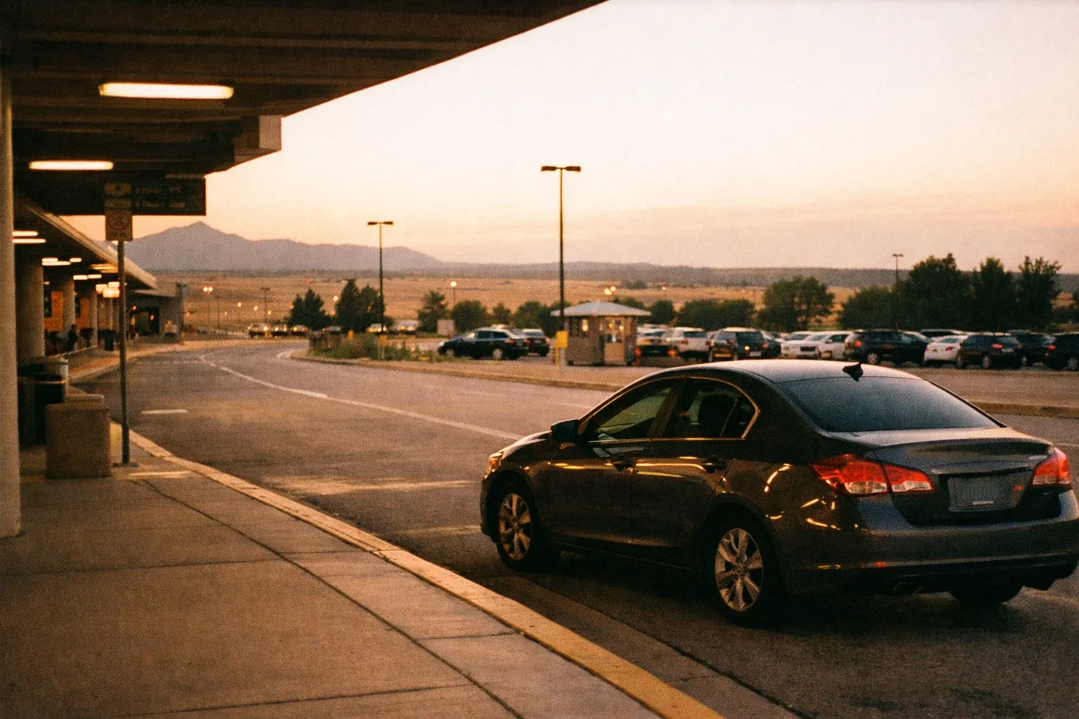COS arrivals curbside pickup area with a waiting vehicle near baggage claim